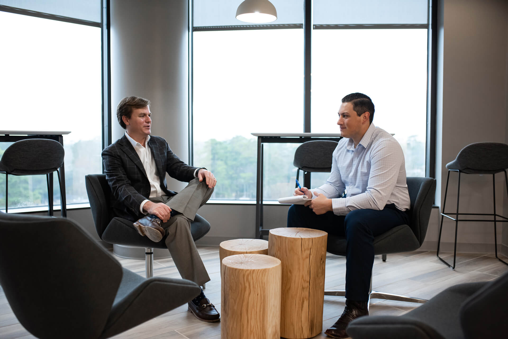 two men sitting and talking in an office